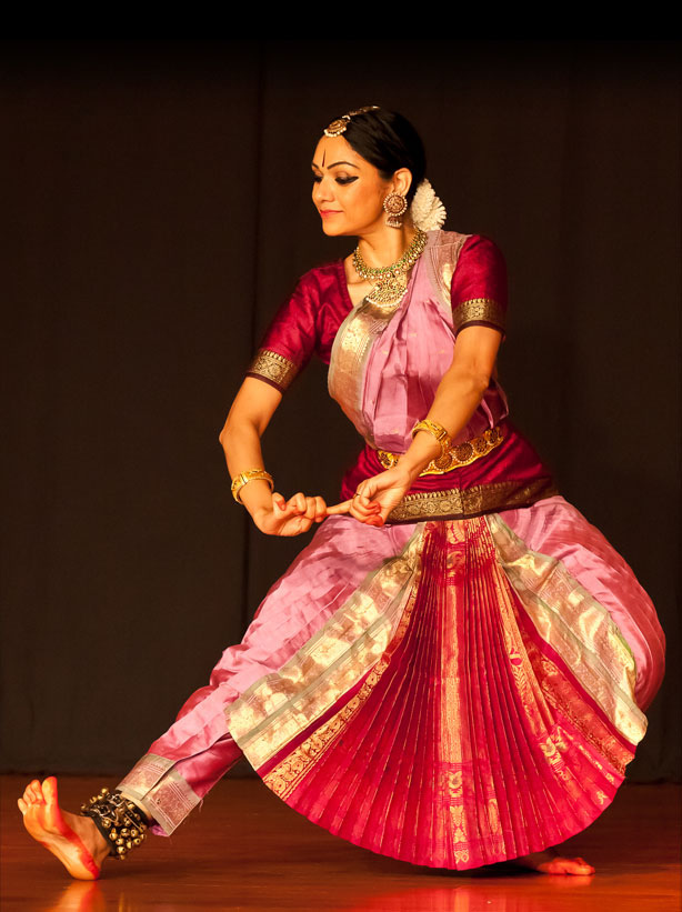 Rama in pink and gold costume, seated in a Bharatanatyam pose